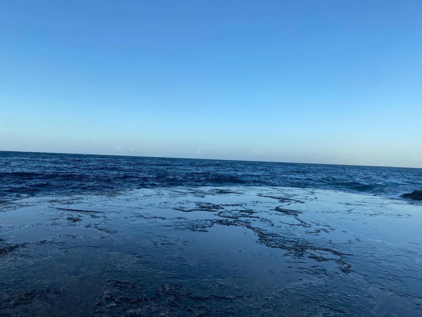 Blue sea horizon and rocky shoreline