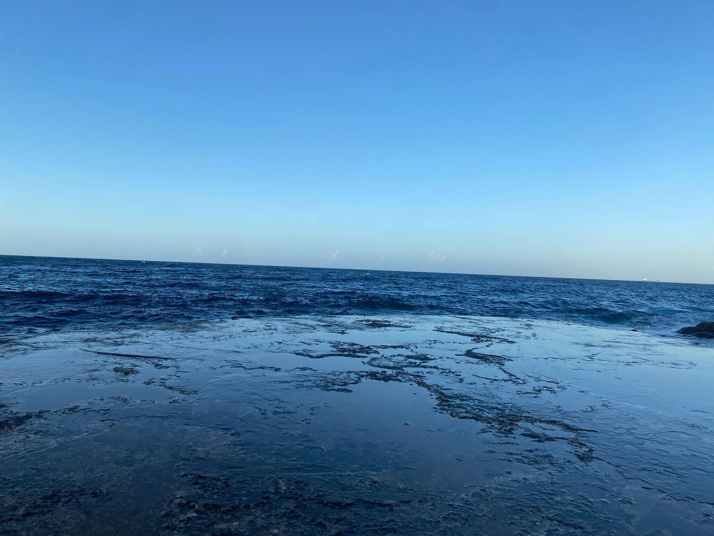 Blue sea horizon and rocky shoreline